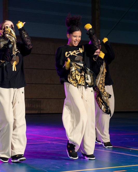 Dansers in zwart en goud tijdens een les